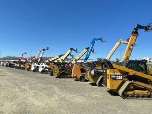 Person comparing rental terms beside compact equipment at a residential worksite.
