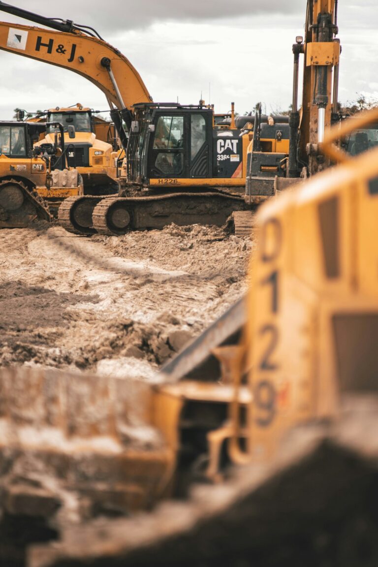 A renter reviews a rental agreement beside a compact loader while inspecting its tires, controls, and visible damage.